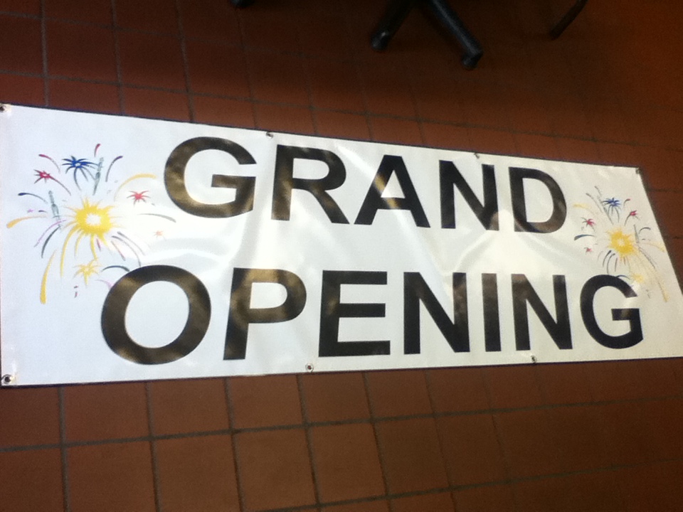 White Grand Opening vinyl banner with gold lettering printed by SpectraColor in Simi Valley
