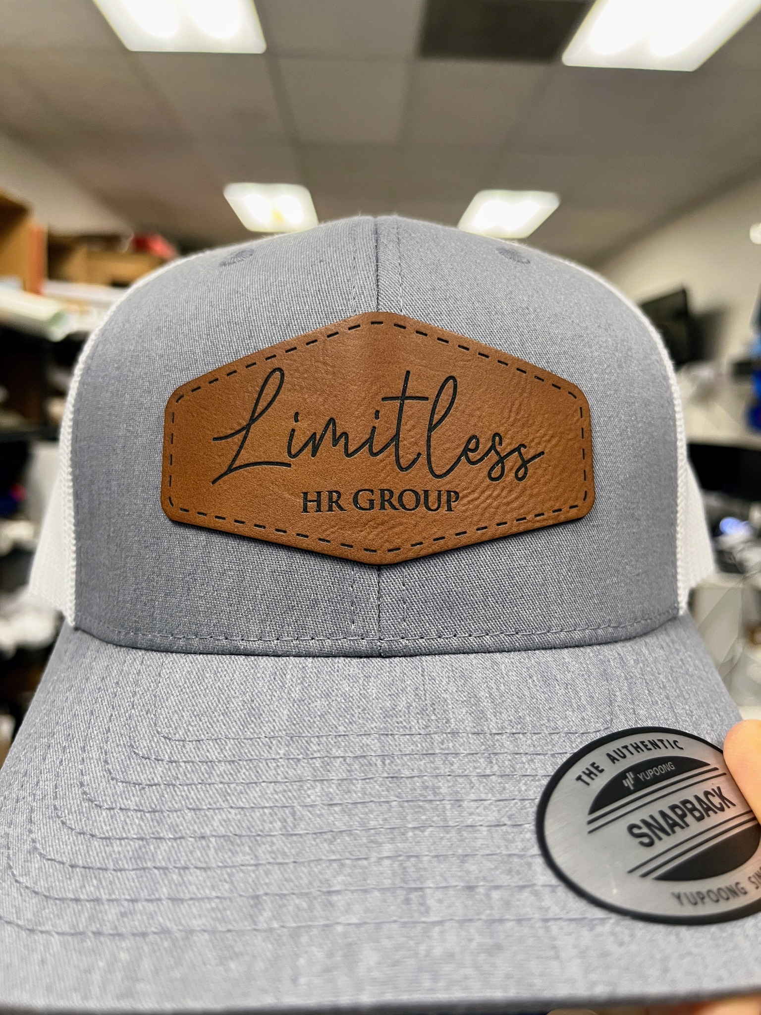 Gray Limitless HR Group hat with a brown shaped logo patch