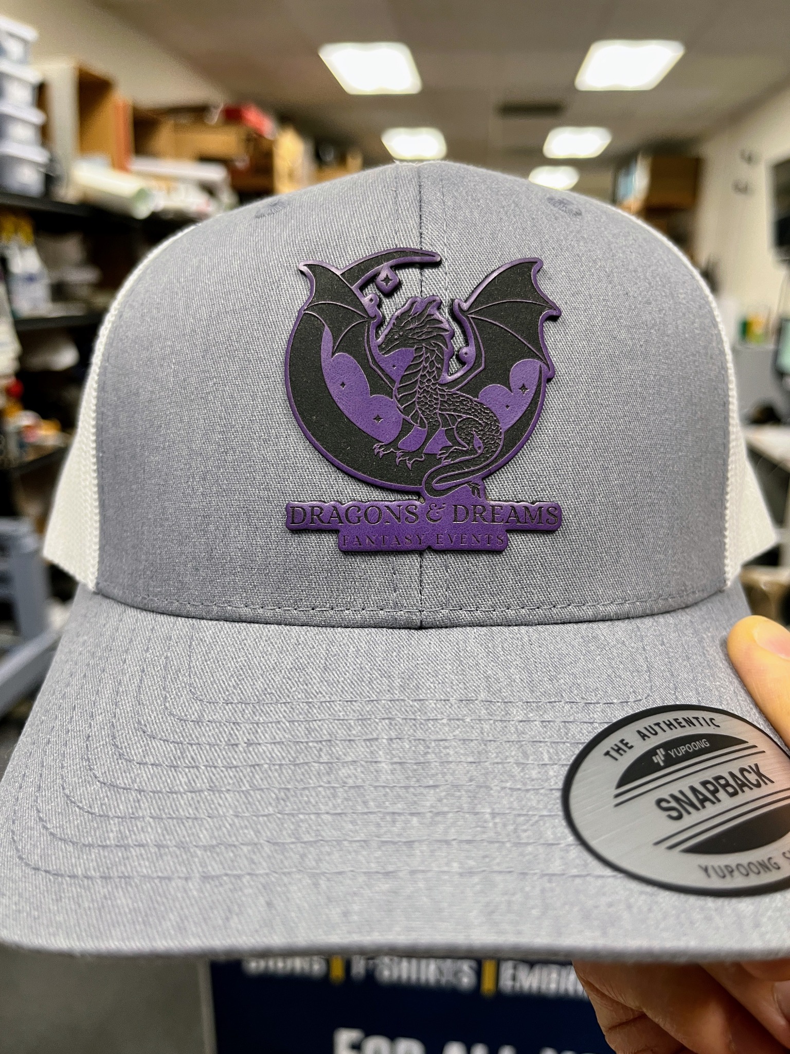 Gray hat with a purple and black dragon logo patch