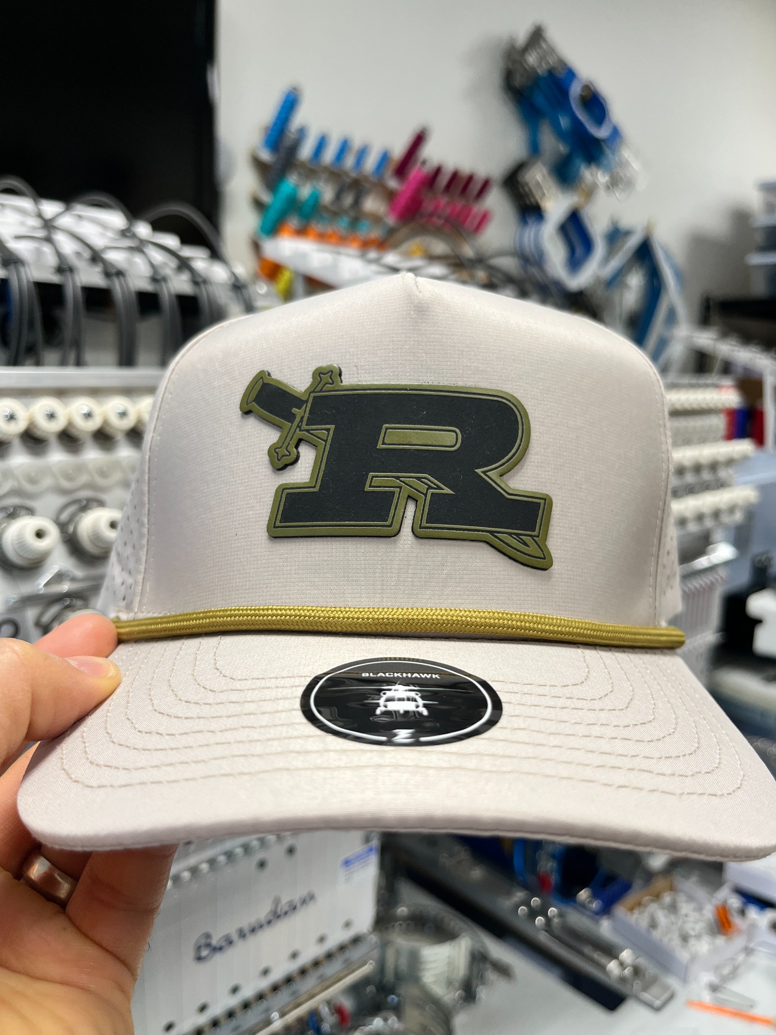 Cream Royal High School hat with a dark R logo patch and contrasting outline