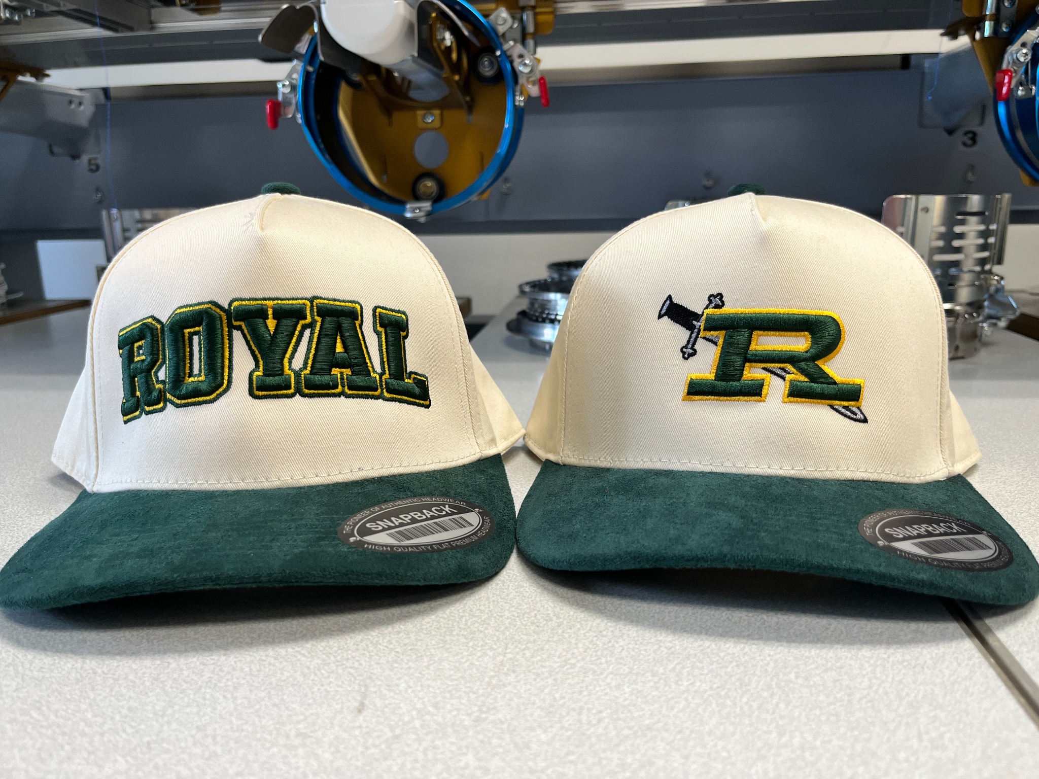Two-tone Royal High School hats with green bills and matching green and gold 3D puff embroidery