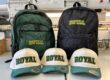 Green and black embroidered Royal High School backpacks behind cream and green Royal hats
