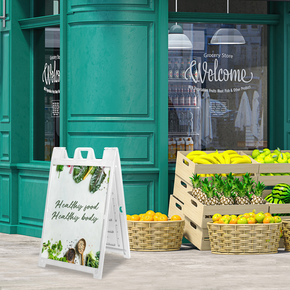 White Deluxe Signicade with printed inserts outside a grocery storefront