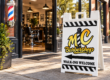 MC Barbershop A-frame sidewalk sign with a left-pointing arrow outside a barber shop entrance — illustrative composite.