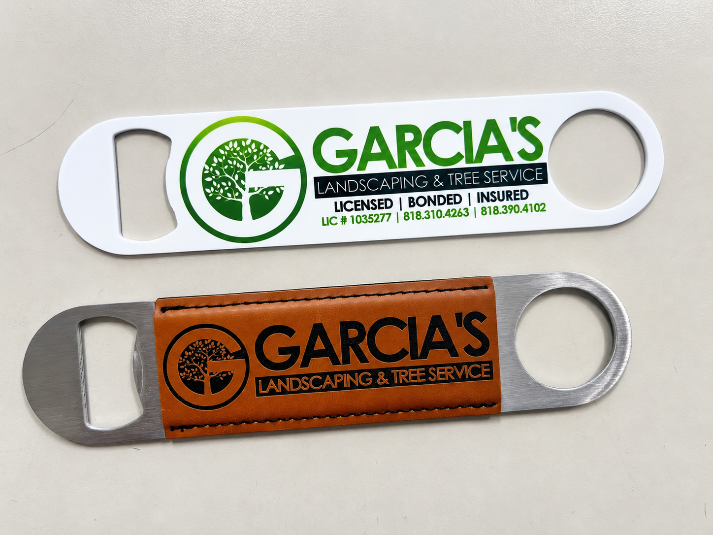 White printed and brown leather-look Garcia’s Landscaping branded bottle openers.