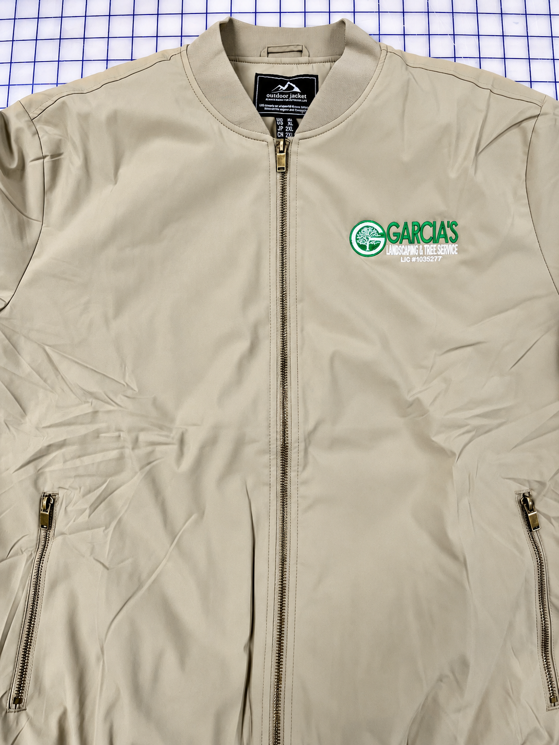 Tan managers’ jacket embroidered with Garcia’s Landscaping and Tree Service chest logo.