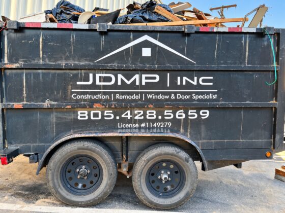 Side view of JDMP Inc. trailer showing white vinyl logo service lettering and phone number
