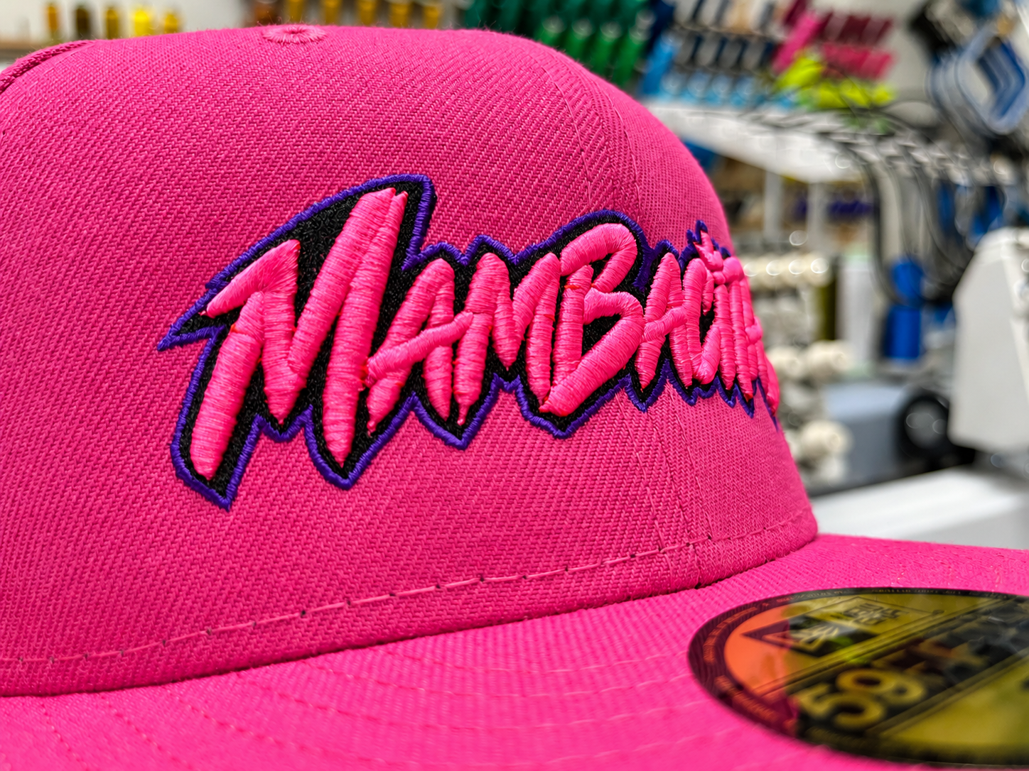 Close-up angle of raised pink Mambacitas embroidery on a pink hat