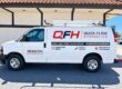 White Quick Flow Hydraulics work van with red and black QFH logo and service lettering