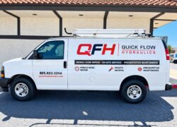 Quick Flow Hydraulics van lettering — driver side White Quick Flow Hydraulics work van with red and black QFH logo and service lettering
