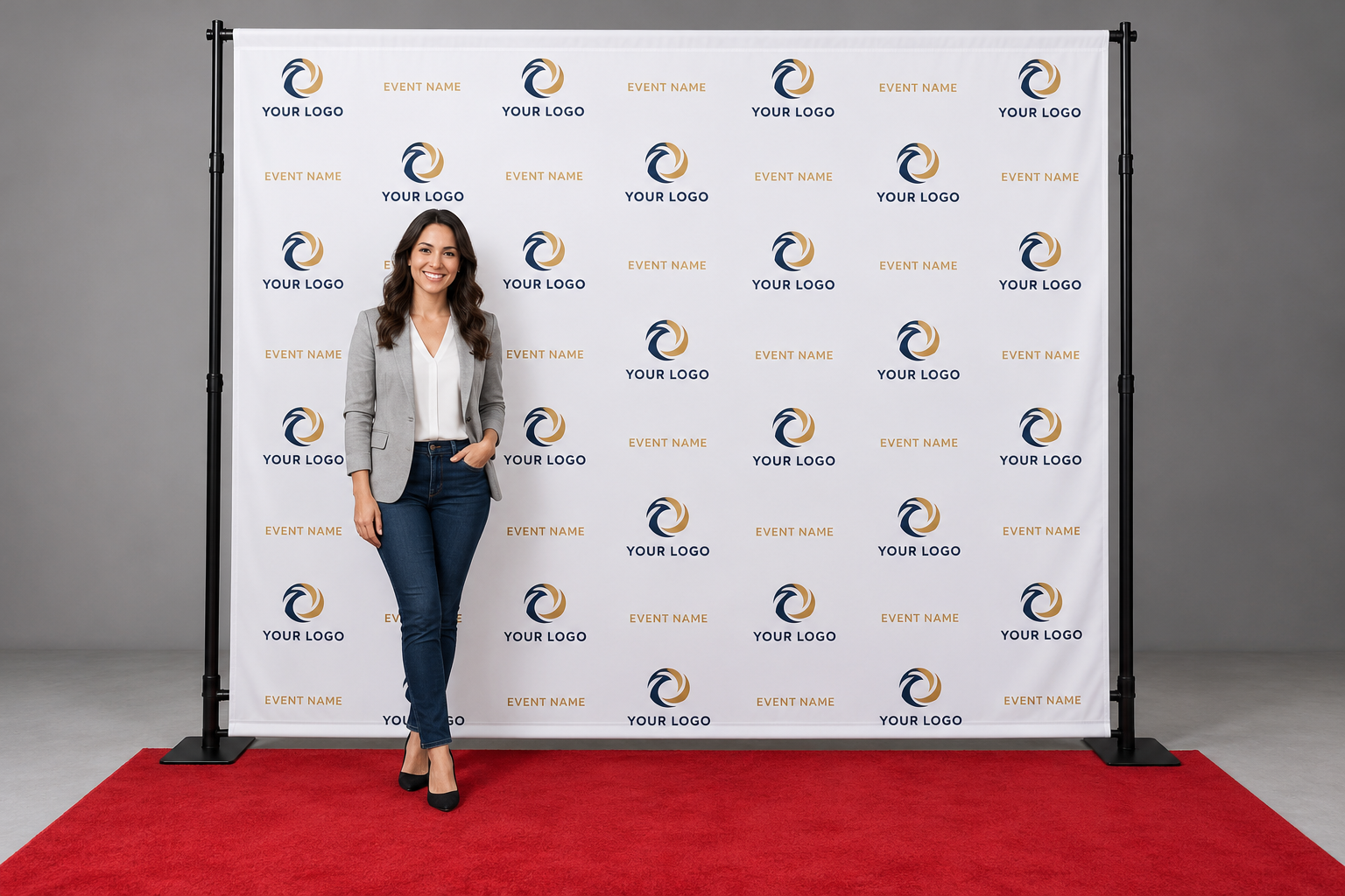 step-repeat-hero Person standing in front of a white step and repeat logo backdrop on a red carpet