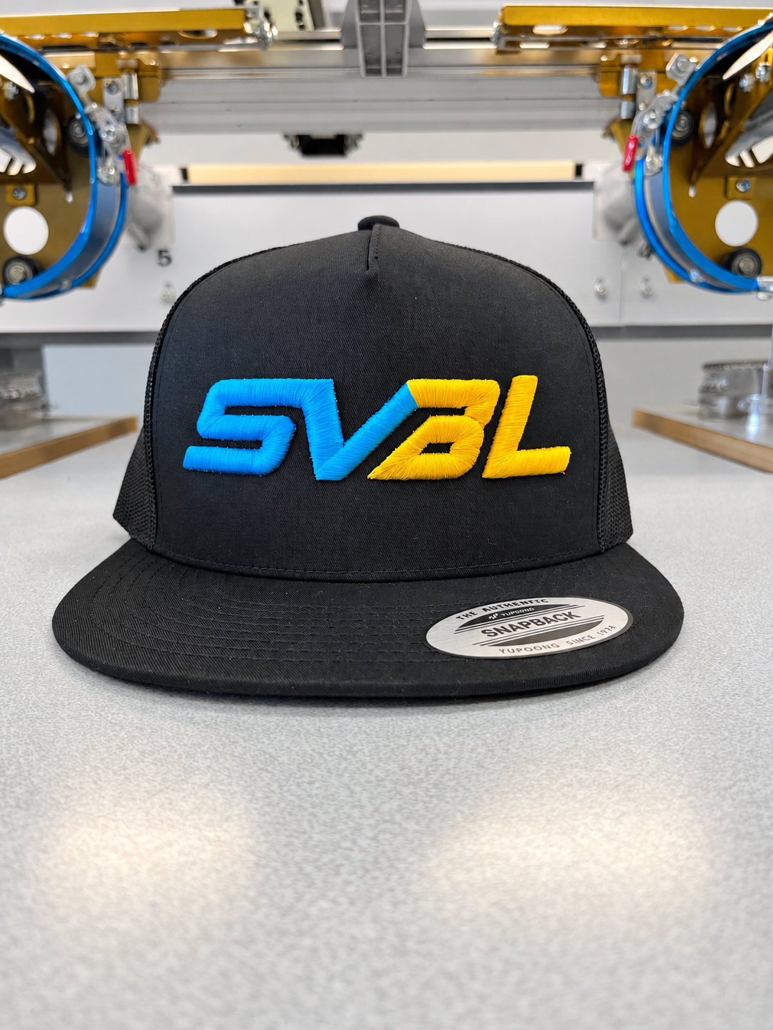 Black SVBL snapback with blue and yellow 3D puff embroidery by SpectraColor in Simi Valley